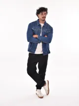 Campera de jean azul con cuello clásico, cierre frontal con botones metálicos, bolsillos con solapa abotonada en el pecho y bolsillos laterales.