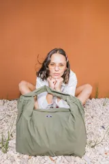 Bolso deportivo tipo duffel bag de nylon color negro, con asas de mano y correa ajustable para hombro. Diseño simple y funcional.