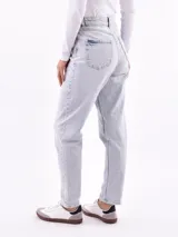 Jeans de mujer color negro lavado, tiro alto, con corte recto o ligeramente cónico y largo al tobillo.