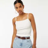 Camiseta sin mangas blanca de canalé con tirantes finos y detalle de encaje en el escote.