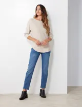 Buzo de tejido rib color beige, con cuello redondo y mangas japonesas de largo tres cuartos.