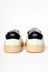 Zapatillas blancas de cuero con detalles en negro en el talón y la lengüeta.