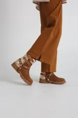 Botas cortas de gamuza color marrón con detalles dorados y hebillas decorativas.