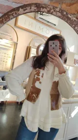 Chaleco de cuero con estampado animal en tonos marrones y blancos. Diseño sin mangas y corte recto.