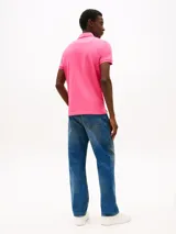 Chomba rosa de corte regular, con cuello tipo chomba, cartera de dos botones y logo de Tommy Hilfiger bordado en el pecho.