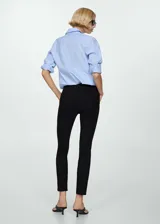 Pantalón cigarette negro con corte a la altura del tobillo y aberturas laterales.
