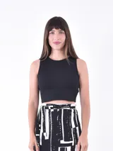 Musculosa corta negra de tejido de punto acanalado, con cuello redondo y sisas anchas.