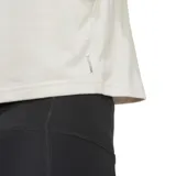 Musculosa deportiva Adidas color crema, corte crop, con logo estampado en el pecho.