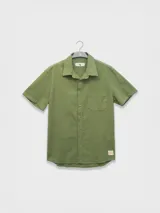 Camisa azul de manga corta confeccionada en algodón ligero con textura waffle. Presenta corte cuadrado, bolsillo en el pecho y botones de coco grabados con el logo de Polonio.