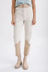 Pantalón de jean color crudo, corte recto, con apliques de gamuza en color beige en la parte inferior de las piernas.