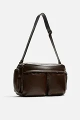 Bandolera marrón de piel envejecida con compartimento principal con cremallera, bolsillo interior plano y con cremallera, dos bolsillos frontales con botón a presión, dos bolsillos laterales con cremallera y asa de hombro ajustable de piel.