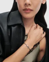 Pulsera PD Paola con cordón negro y dije de plata en forma de media luna.