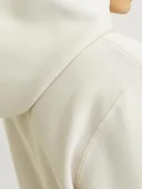 Hoodie color beige de manga larga y cuello con capucha. Tiene un fit holgado con bolsillo canguro.