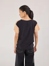 Remera negra de algodón con mangas cortas con detalle de calado y bordado en los hombros y mangas. Corte recto con cintura ajustable con cordón.