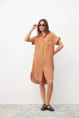 Vestido camisero color tostado de lino con cuello clásico, manga corta con dobladillo, cierre frontal con botones y bolsillo de parche en el pecho.