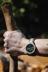 Reloj Vernoir con caja de madera de Zebrano y malla de Chacate Preto con incrustaciones de madera de Zebrano. Esfera negra con marcadores minimalistas en blanco y manecillas negras.