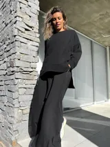 Conjunto negro compuesto por un remerón oversize de mangas largas y un pantalón palazzo de tiro alto con elástico en la cintura.