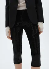 Calza capri negra cubierta de lentejuelas, con cintura elástica y corte skinny.