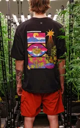 Remera negra de corte oversize con hombros caídos y cuello redondo. Estampado en la espalda con tres imágenes rectangulares apiladas y una ilustración de un sol con plantas de cannabis.
