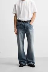 Pantalón de jean celeste con efecto lavado, corte flare fit y caída baggy desde la rodilla hasta el tobillo. Tiene cinco bolsillos y cierre frontal con botones.