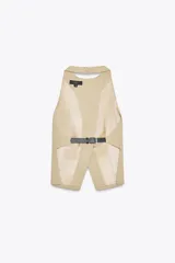 Top chaleco color beige de cuello halter con espalda descubierta y trabilla con hebilla metálica. Cierre frontal con botones y ganchos metálicos.