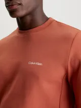 Buzo color ladrillo de algodón y poliéster con cuello redondo, puños y bajo acanalados. Presenta un pequeño logo de Calvin Klein en el pecho.