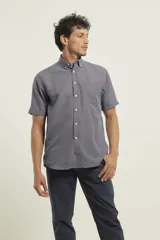 Camisa de manga corta azul con microestampado blanco, cuello abotonado, corte clásico y bolsillo en el pecho.