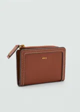 Billetera rectangular color marrón con cierre de solapa con botón magnético y bolsillo interior con cierre de cremallera.