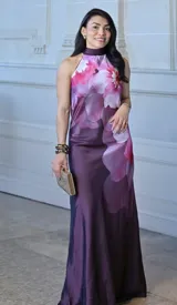 Vestido largo de fiesta con estampado floral en tonos rosados y morados, con cuello halter y corte al bies.