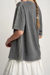 Remera gris con estampa de la palabra "Tierra" y signos zodiacales.
