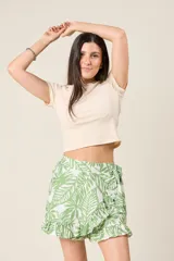 Short pollera con estampado de hojas, diseño cruzado, volados y lazo en la cintura.