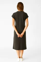 Vestido de algodón gris oscuro con efecto gastado, corte recto y holgado hasta la rodilla. Presenta mangas cortas dobladas y un estampado frontal en tonos claros con texto y un diseño gráfico central.