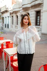 Camisa color beige con encaje en la parte delantera y en las mangas, de corte holgado.