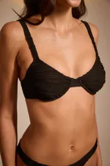 Conjunto de bikini negro con textura arrugada, compuesto por corpiño con aro y breteles anchos, y bombacha tipo colaless.