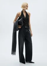Chaleco negro con cuello halter, espalda descubierta y cierre frontal con botones.