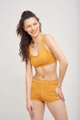 Top deportivo color mostaza con espalda nadadora y breteles anchos.