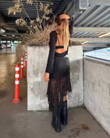 Minifalda negra de encaje con forro, con una capa de encaje más larga y asimétrica que llega hasta la pantorrilla.