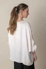 Blusa italiana holgada de color negro con cuello redondo y mangas 3/4 con detalle de lazos.