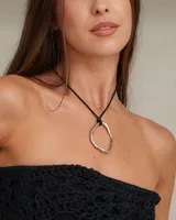 Collar con dije circular irregular de alpaca y plata 925, con hilo de algodón natural.