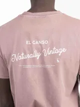 Camiseta de manga corta color rosa con cuello redondo y logo bordado en el pecho.