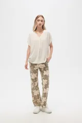 Pantalón de lino color verde oliva con estampado de flores color crema, de corte recto.