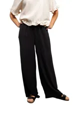 Pantalón negro de tiro alto, corte suelto y elástico ajustable en la cintura.