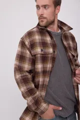 Sobrecamisa de hombre de manga larga con cierre de botones. Diseño a cuadros en tonos marrón, beige y verde. Confeccionada en tejido de sarga de lana, poliéster, acrílico y nylon.