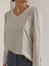 Remera gris claro de algodón con mangas largas abullonadas y escote en V.