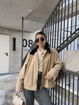 Campera de pana color beige con cierre frontal y cuello negro.