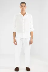 Pantalón de lino blanco con cintura elástica y cordón ajustable. Corte recto y holgado.