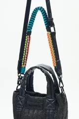 Cartera tote mini color negro, confeccionada en tejido tipo rafia. Cuenta con bolsillos internos, dos correas desmontables y abertura superior con cierre.