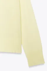 Jersey de punto color borgoña, con cuello redondo, manga larga y bajo con aberturas laterales.