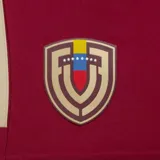 Short deportivo Adidas color bordó con cintura elástica. Presenta tres franjas laterales en color beige claro y el logo de Adidas en dorado. Incluye un escudo bordado en el frente izquierdo con los colores de la bandera de Venezuela.