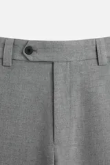 Pantalón gris de corte recto confeccionado en tejido con lana. Cuenta con bolsillos frontales y traseros de vivo con botón. Cierre frontal con cremallera y botón.